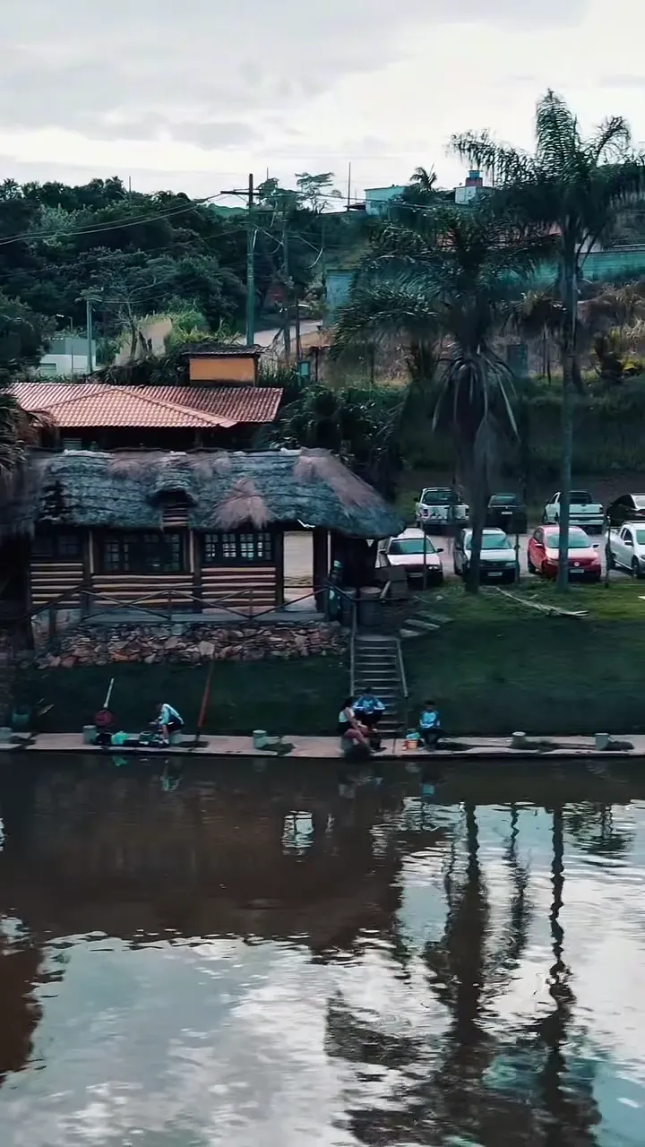 Casa de sapê refletida no lago